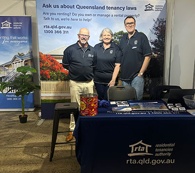 Three people from the Residential Tenancies Authority’s Education team pose alongside their display at the 2026 Ekka.