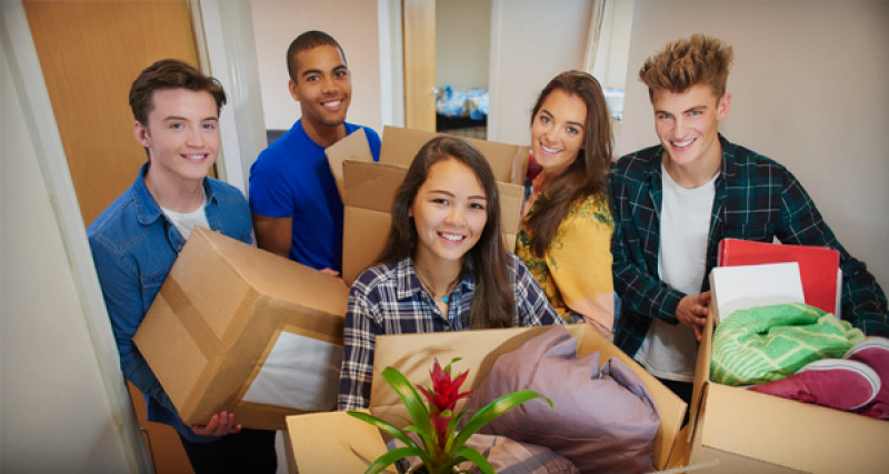 Young people packing moving boxes