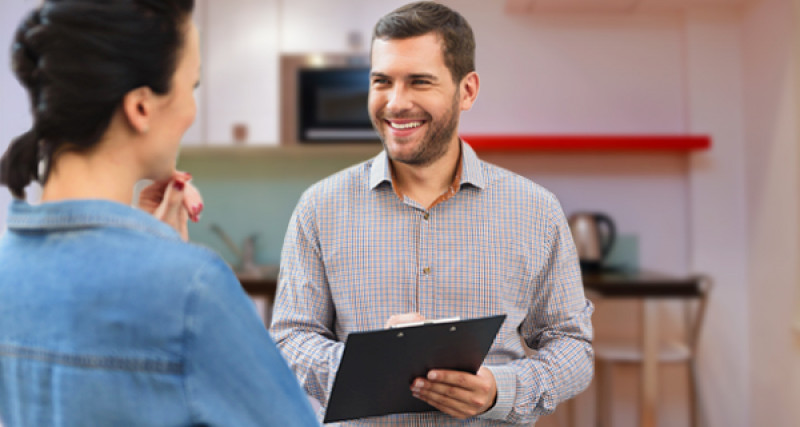 Man with clipboard talking to a woman