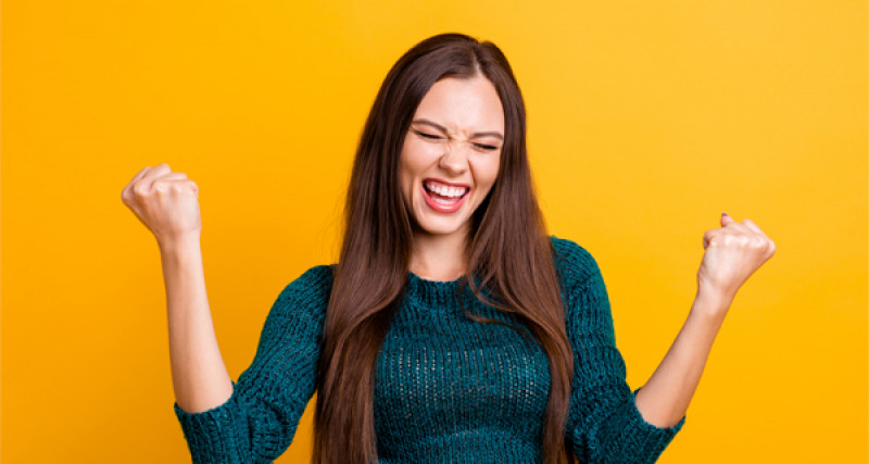 Young woman clenching fists and smiling