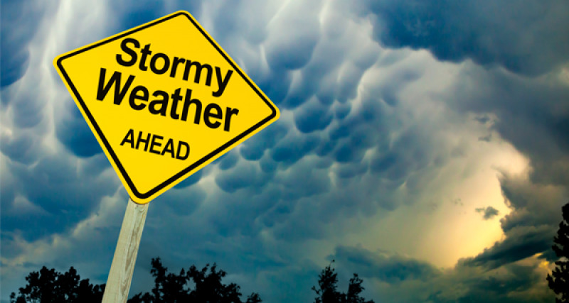 Outdoor sign with the words Stormy weather ahead written on it
