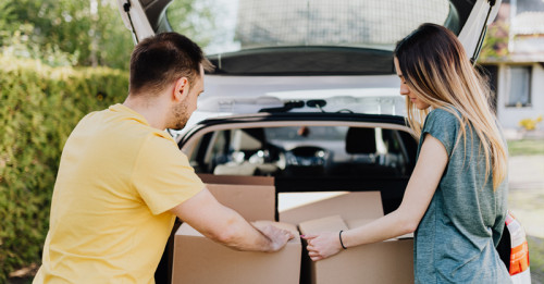 A man and woman packing boxes into a car