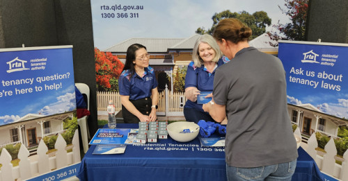 Two Residential Tenancies Authority staff provide tenancy information and resources to a community member at an information booth at the Toowoomba Show 2026.