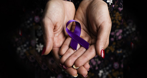 Hands holding a purple ribbon