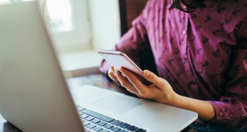 Woman with laptop and mobile phone