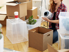 woman packing personal items in bubble wrap.